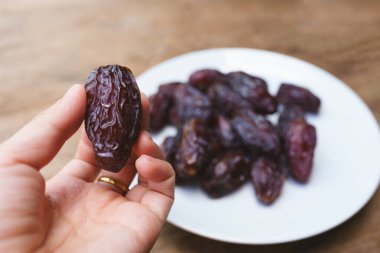Bir kadının elinde tutulan kurumuş Medjool meyveleri besin değeri yüksek meyvelerdir..