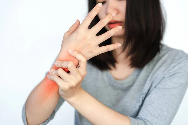 Woman has wrist pain or arm pain from heavy use on white background.