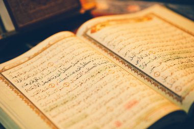 Kur 'an okumak için açıldı ve loş bir altın parıltısı vardı. Seçici odaklanma. İslam kavramı.