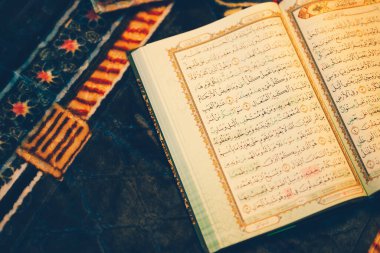Kur 'an okumak için açıldı ve loş bir altın parıltısı vardı. Seçici odaklanma. İslam kavramı.
