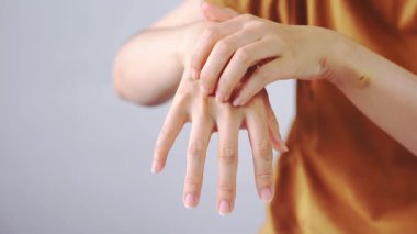 Eklem ağrısı ya da sertlik nedeniyle el masajı yapan genç bir kadının yakın çekimi, sağlık sorunları, yaralanma ya da ilkel eklem iltihabını gösteriyor. Tıbbi, sağlık, fizyoterapi ve önleme kavramları için ideal.