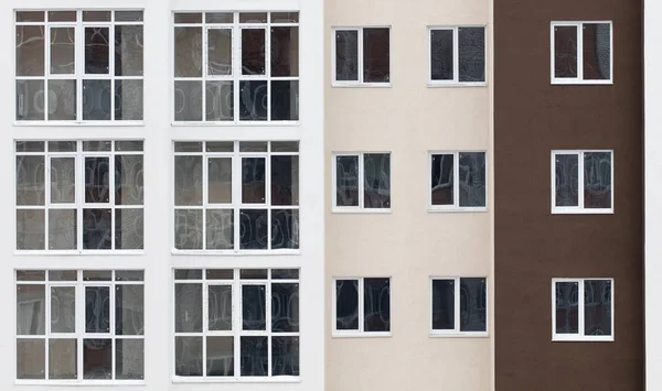 Wall of a residential block of flats with balconies windows