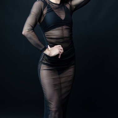 Siyah arka planda seksi siyah elbiseli seksi sarışın kız.