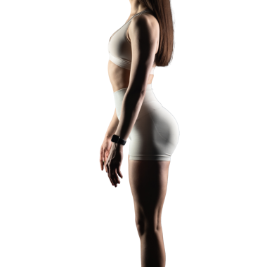 Beyaz arka planda spor giyimli genç bir kadın.