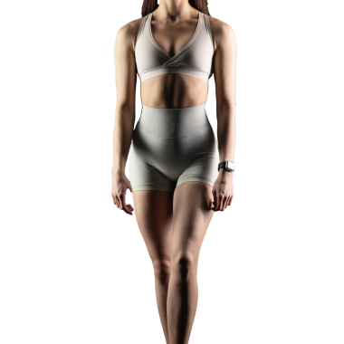 Beyaz arka planda spor giyimli genç bir kadın.