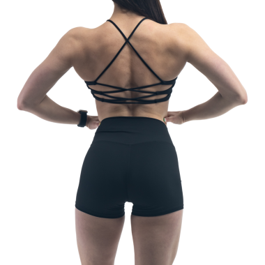 Beyaz arka planda spor giyimli genç bir kadın.