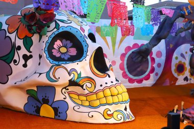 Santa Pola, İspanya - 15 Ekim 2023 Polo Park lunaparkı. Canlı, çiçek desenli şeker kafatası, festival arkaplanına karşı kurulmuş, kültürel önemi ve sanatsal zanaatkarlığı gözler önüne seriyor.