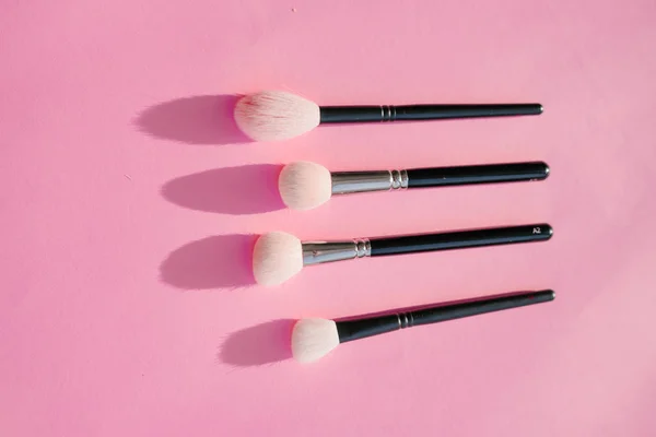makyaj pembe bir arka plan üzerinde siyah renkli için fırçalar pahalı kümesi