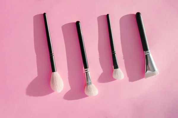 makyaj pembe bir arka plan üzerinde siyah renkli için fırçalar pahalı kümesi