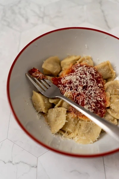이탈리아 토마토 소스를 곁들인 만두와 대리석 배경의 포크가 세라믹 플레이트파마산 — 스톡 사진