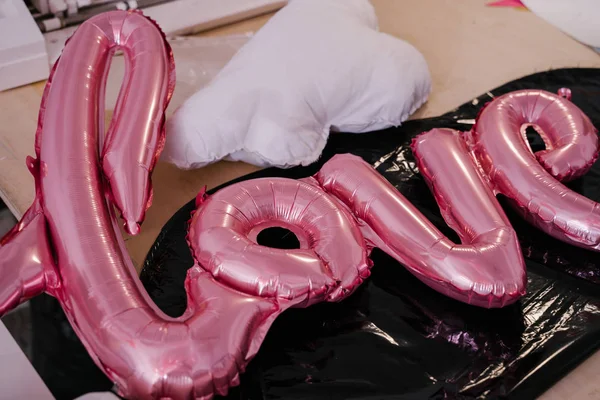 pink  balloon in form of word love on table, birthday party concept