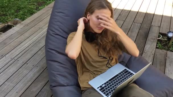 Jovem Mulher Trabalhando Laptop Enquanto Senta Cadeira Beanbag Terraço Madeira — Vídeo de Stock