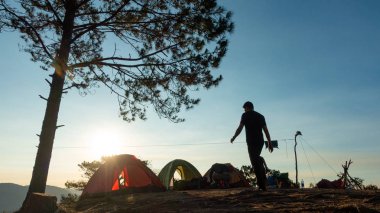 Gündoğumu peyzaj açık seyahat kamp tatil. Yüksek kaliteli stok görüntü dağ ve orman Sunrise kamp çadır. Macera seyahat kamp Turizm ve çadır altında çam ormanı