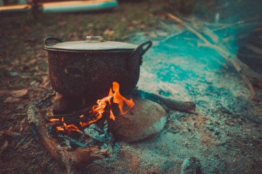 Kamp ve piknik üzerinde kamp ateşi, pot sabah kaynama alan koşullarında pişirme. Yakacak odun üzerinde yemek zaman vahşi veya açık hava etkinliği, kamp çadır için gidiş yakacak odun kullanarak soba