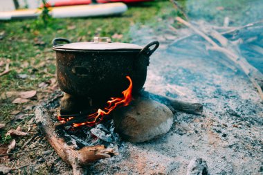 Kamp ve piknik üzerinde kamp ateşi, pot sabah kaynama alan koşullarında pişirme. Yakacak odun üzerinde yemek zaman vahşi veya açık hava etkinliği, kamp çadır için gidiş yakacak odun kullanarak soba