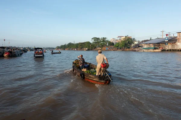 Tourists and people buy and sell food, vegetable, fruits on vessel, boat, ship in Cai Rang floating market at Mekong River. Royalty free stock image of the floating market or river market in Vietnam