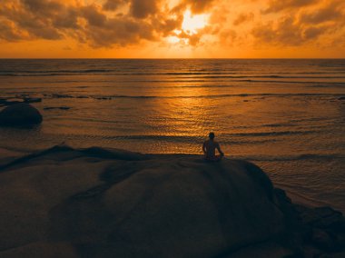 Pratik yoga sahilde günbatımı veya gündoğumu bir adam. Stok görüntü peyzaj cennet tropikal ada plaj ve yoga ve meditasyon plaj sabah güneş doğarken pratik bir adam. Sağlıklı yaşam tarzı