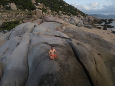 Pratik yoga sahilde günbatımı veya gündoğumu bir adam. Stok görüntü peyzaj cennet tropikal ada plaj ve yoga ve meditasyon plaj sabah güneş doğarken pratik bir adam. Sağlıklı yaşam tarzı