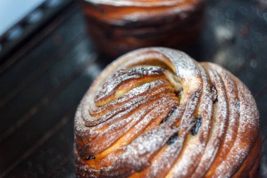 Kek pasta krizi bir rulo şeklinde koyu arka plan ve antika bir ızgara üzerinde pudra şekeri serpilir. Paskalya ve Noel pişirme. Üstten Görünüm, metin, yer yakın çekim.