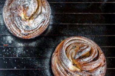 Kek pasta krizi bir rulo şeklinde koyu arka plan ve antika bir ızgara üzerinde pudra şekeri serpilir. Paskalya ve Noel pişirme. Üstten Görünüm, metin, yer yakın çekim.