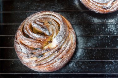 Kek pasta krizi bir rulo şeklinde koyu arka plan ve antika bir ızgara üzerinde pudra şekeri serpilir. Paskalya ve Noel pişirme. Üstten Görünüm, metin, yer yakın çekim.