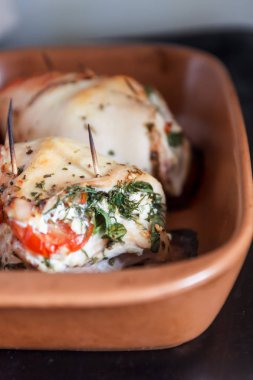 Fırında tavuk fileto yumuşak peynir, domates ve bir seramik tabak pişirme otlar ile doldurulmuş. Doğru yararlı sağlık gıda, beslenme kavramı.
