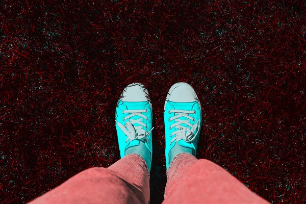 Legs in old sneakers on grass. View from above. Style: abstraction, illustration, monochrome, neon.