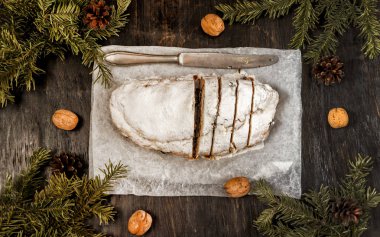 Geleneksel Alman Noeli meyve pasta stollen çam dalları ve ceviz etrafında karanlık bir arka plan üzerinde. Yukarıdan görüntülemek için alanı, düz yatıyordu kopyalama.