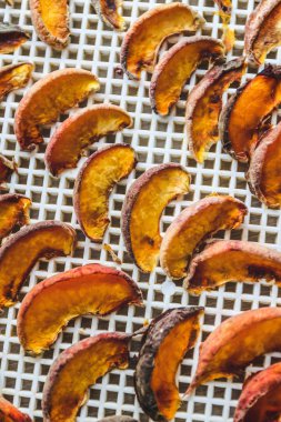 Kurutucuda kurutulmuş şeftali. Vitaminleri korumanın bir yolu. Vejetaryen yemeği, sağlıklı ve yararlı..