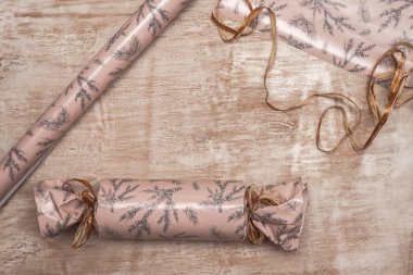 Bir Noel ve yeni yıl hediye, Ladin, sicim, ip, yeşil ve pembe kağıt ahşap arka plan üzerinde bir dalı paketleme işlemi. Görünümü ana sayfa, yer kopyalayın, yat.