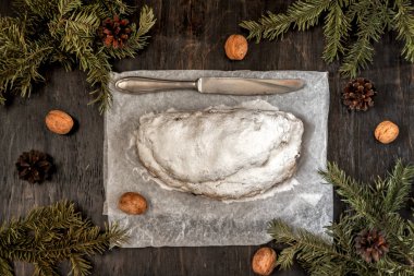 Geleneksel Alman Noeli meyve pasta stollen çam dalları ve ceviz etrafında karanlık bir arka plan üzerinde. Yukarıdan görüntülemek için alanı, düz yatıyordu kopyalama.