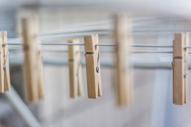 Çamaşır ipinde ahşap mandallar, bulanık, hafif bir fotoğraf. Eko-tüketim kavramı, doğal maddelerin kullanımı, farkındalık.