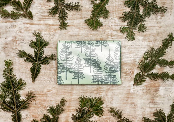Een Geschenk Verpakt Feestelijk Kerstpapier Een Houten Ondergrond Met Verse — Stockfoto
