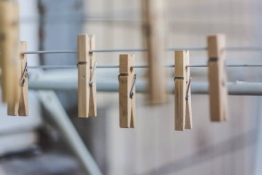 Çamaşır ipinde ahşap mandallar, bulanık, hafif bir fotoğraf. Eko-tüketim kavramı, doğal maddelerin kullanımı, farkındalık.