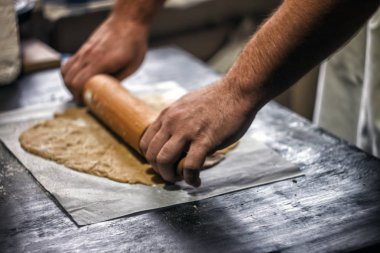Erkek ellerini kurabiye zencefilli kurabiye hamur rulo. Yakın çekim, üstten görünüm. Noel gingerbread veya pizza pişirme için.