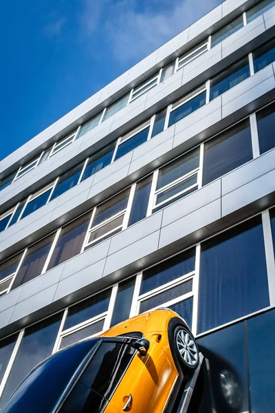 Yellow Car Rides Glass Building Skyscrapers Blue Clear Sky — Stock Photo, Image