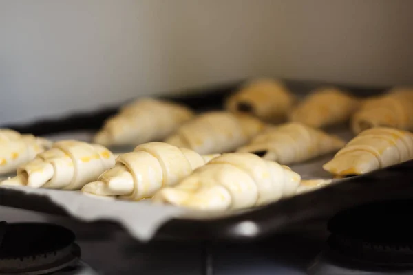 Croissants crudos con chocolate en una bandeja para hornear antes de hornear —  Fotos de Stock