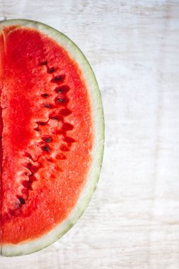 Yarım bir sulu karpuz ışık Beyaz ahşap zemin, clos üzerinde