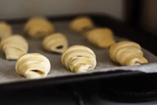 Croissants crus com chocolate em uma assadeira antes de assar — Fotografia de Stock