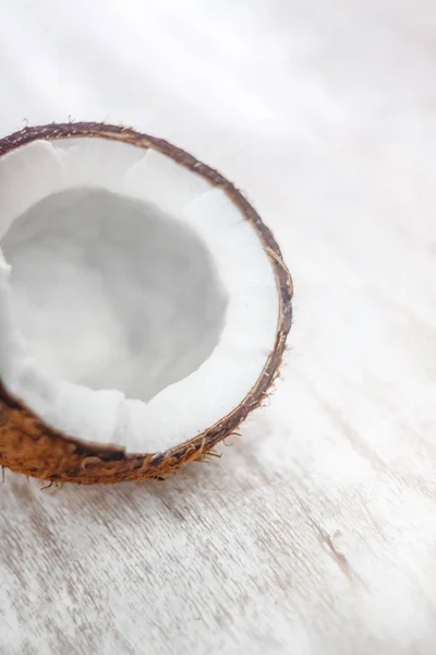 Meio coco em um fundo de madeira branco claro, close-up. Topo vi — Fotografia de Stock