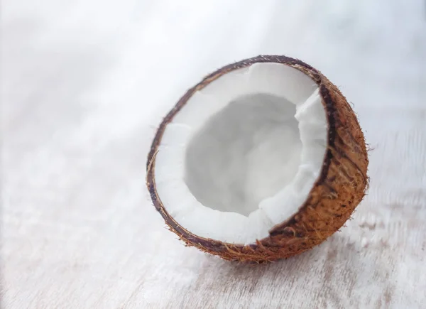 Meio coco em um fundo de madeira branco claro, close-up. Topo vi — Fotografia de Stock