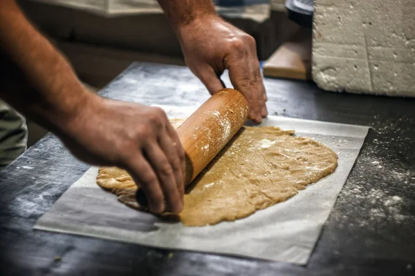 Male hands roll out shortbread gingerbread dough. Close-up, top — Stock Photo, Image
