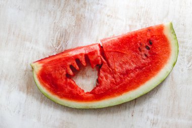 Bir çocuğun eli ile sulu kırmızı karpuz bir yığın içinde oyulmuş