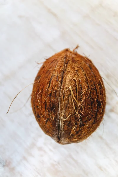 Hele kokosnoot op een witte houten achtergrond. — Stockfoto