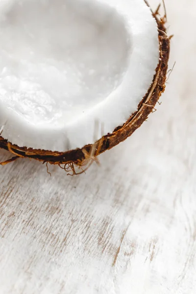 Halva kokos på en vit trä bakgrund, närbild. Topp vi — Stockfoto