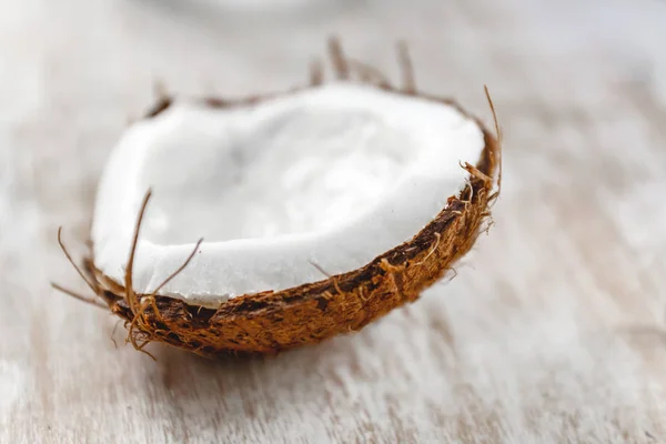 Meio coco em um fundo de madeira branco claro, close-up. Topo vi — Fotografia de Stock