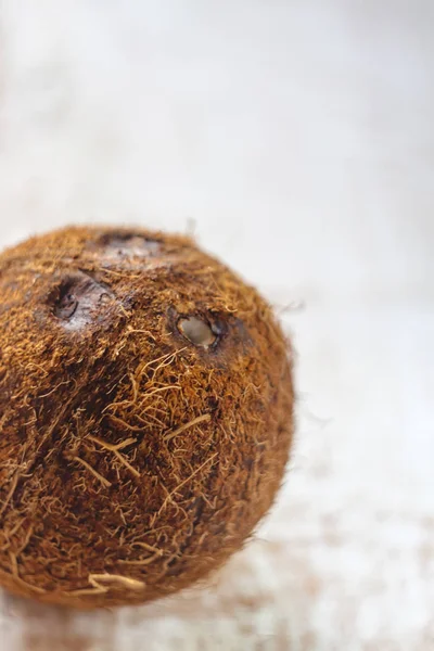 Hela kokos på en vit trä bakgrund. — Stockfoto