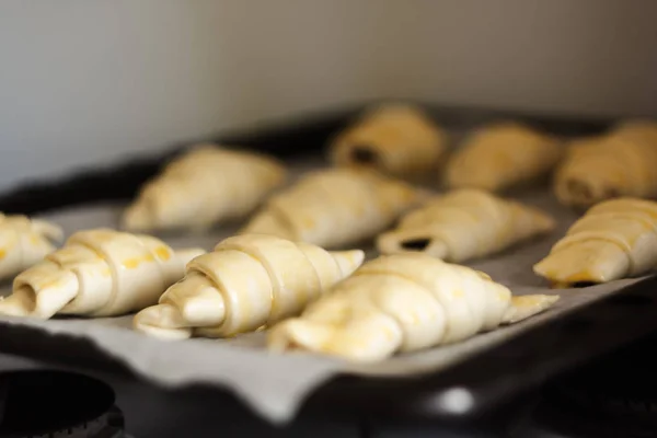 Croissants crudos con chocolate en una bandeja para hornear antes de hornear — Foto de Stock