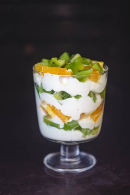 Tatlı şeffaf bir cam, yoğurt, turuncu, kivi, nu katmanlı