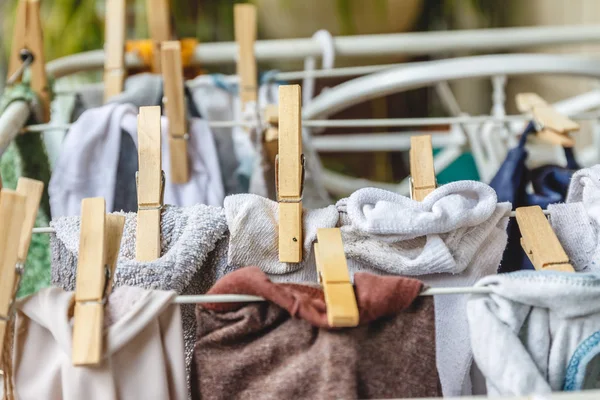 Wit en gekleurd linnen te worden gedroogd op de waslijn met hout — Stockfoto